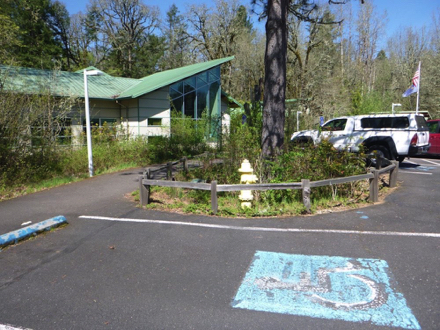 Accessible parking spaces with hard surface pathway in front of them - entrance to nature center and trailhead